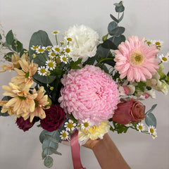 Bouquet of flowers with pink, white, and green colors on a light gray background