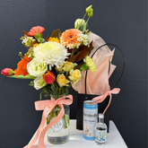 Bouquet of flowers with a can and bottle on a dark background