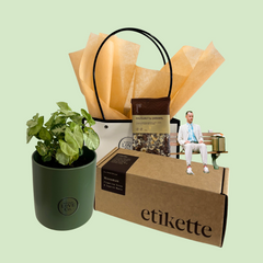 Gift set with a plant, bag, and box labeled 'etikette' on a light green background