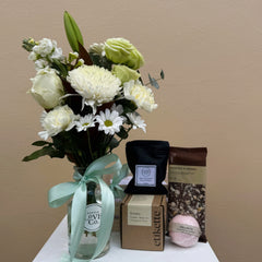 Bouquet of flowers with a box and bags on a beige background